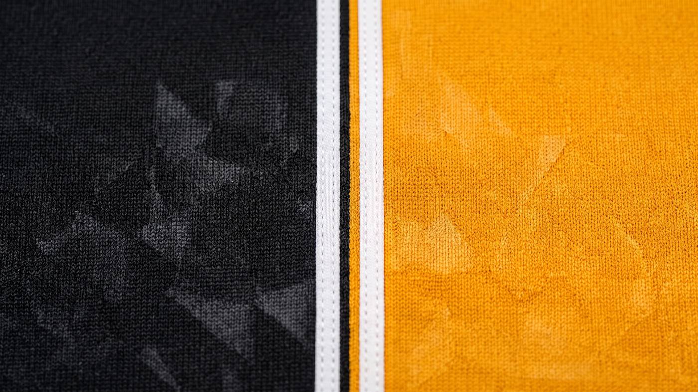 Close-up of the Falcons jersey: black and gold panels split by twin white stripes